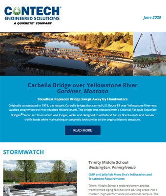 Two women sit on a bench at a bus stop, one looking at her phone, with city buildings and trees in the background.