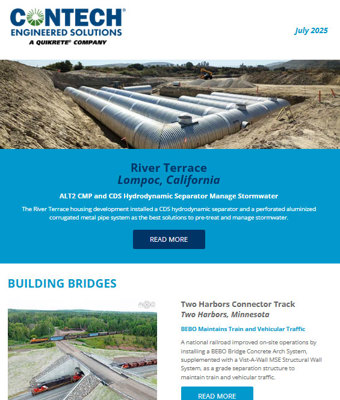 Large stormwater pipes installed underground at a construction site with workers and equipment visible in the background.