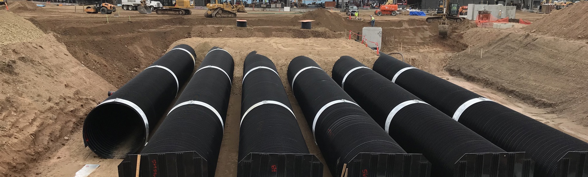 A DuroMaxx rainwater harvesting cistern is under construction outside a stadium. 