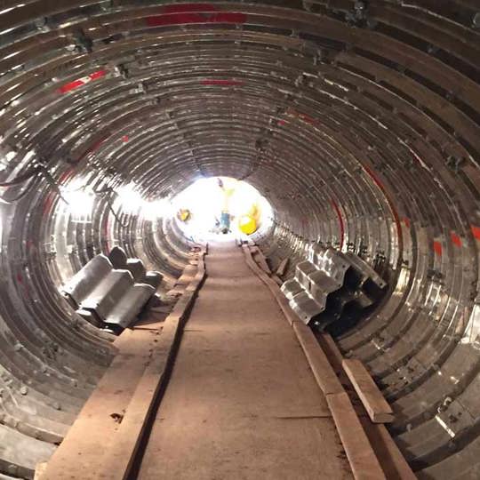 A tunnel is under construction using a Contech tunnel liner plate.
