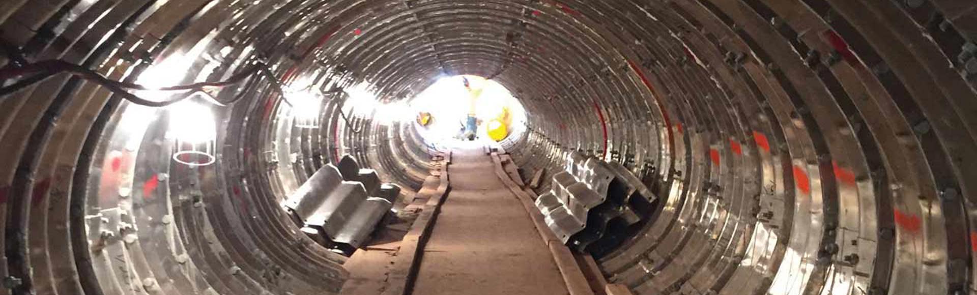 A tunnel is under construction using a Contech tunnel liner plate.