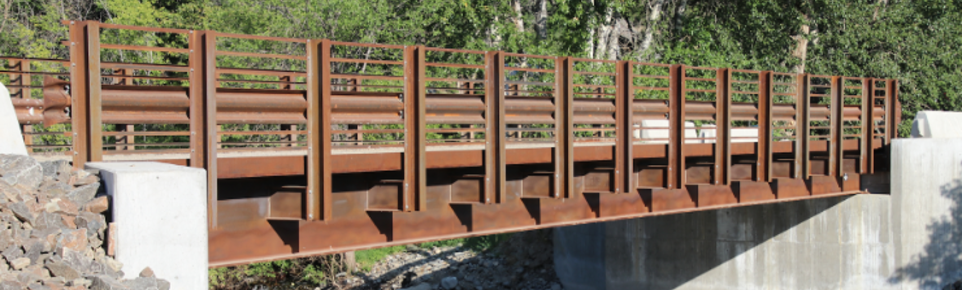 Big R steel rolled girder bridge over a river. 